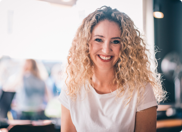 Bild von Moderatorin Claudine Petit - lächelnde blonde Frau mit langen Locken