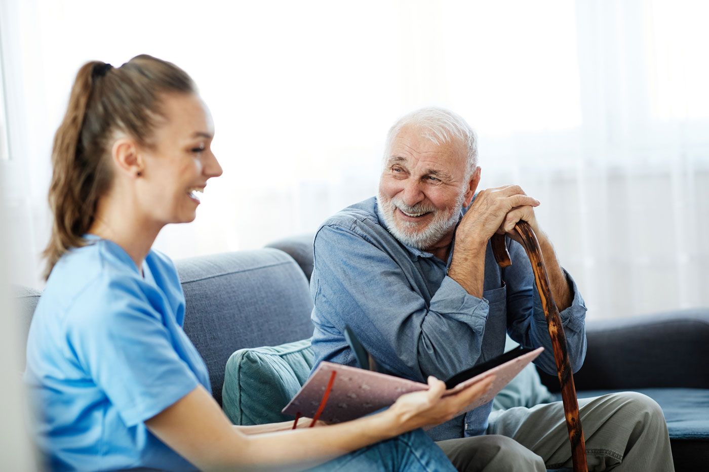 Eine Krankenschwester betreut einen älteren Herrn.  