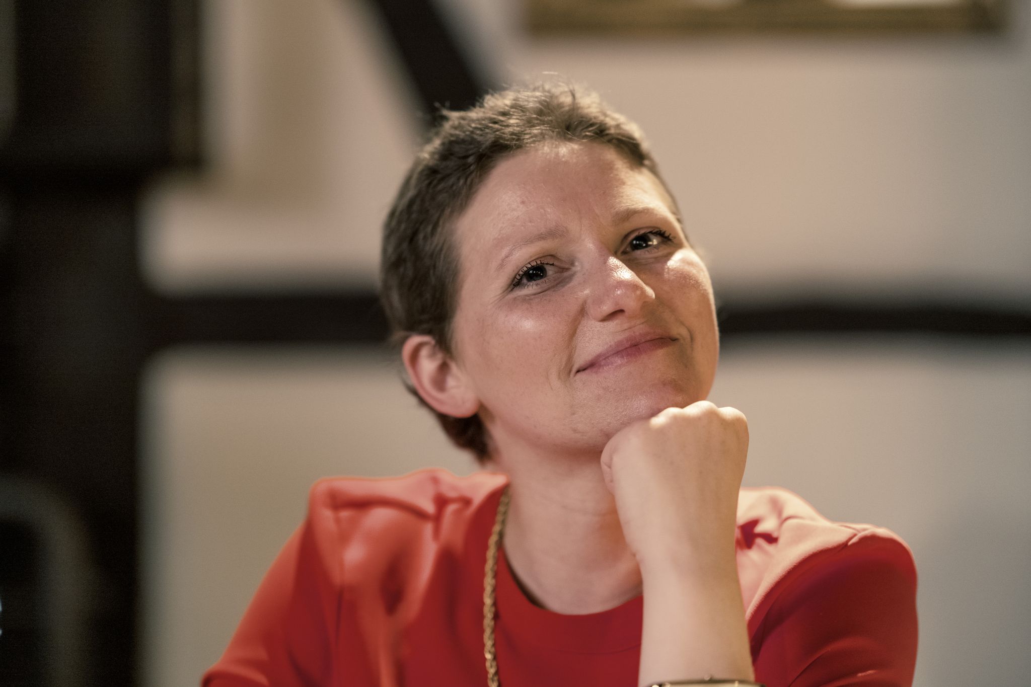 Silja blickt, das Kinn auf ihre linke geballte Faust aufgestützt, lächelnd in die Kamera.