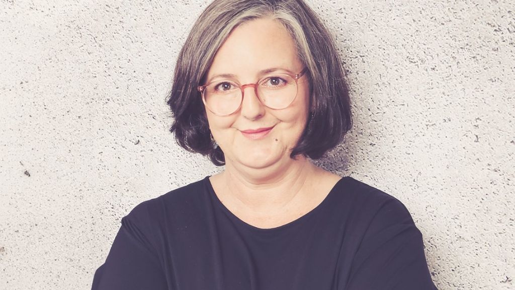 lächelnde Frau mit mittellangen Haaren und Brille