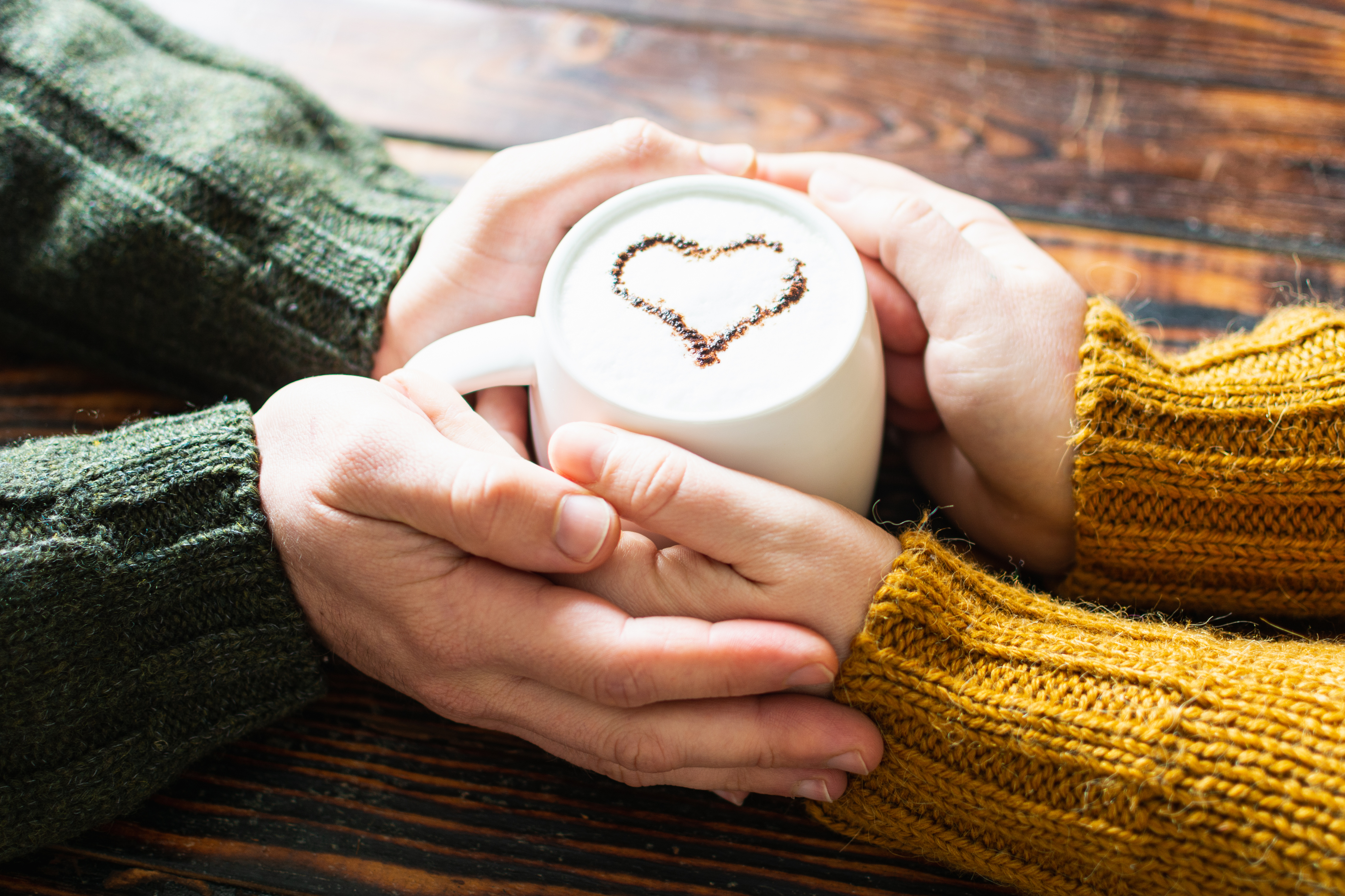 Kaffeetasse mit 2 sich berührenden Händen