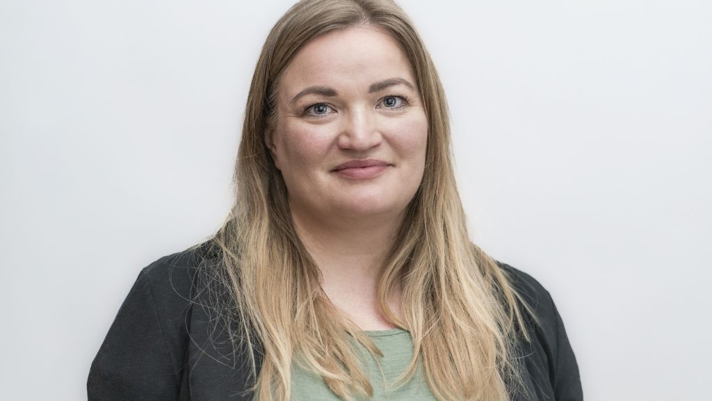 junge Frau mit blonden langen Haaren und schwarzem Blazer