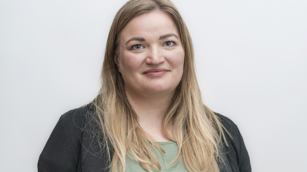junge Frau mit blonden langen Haaren und schwarzem Blazer