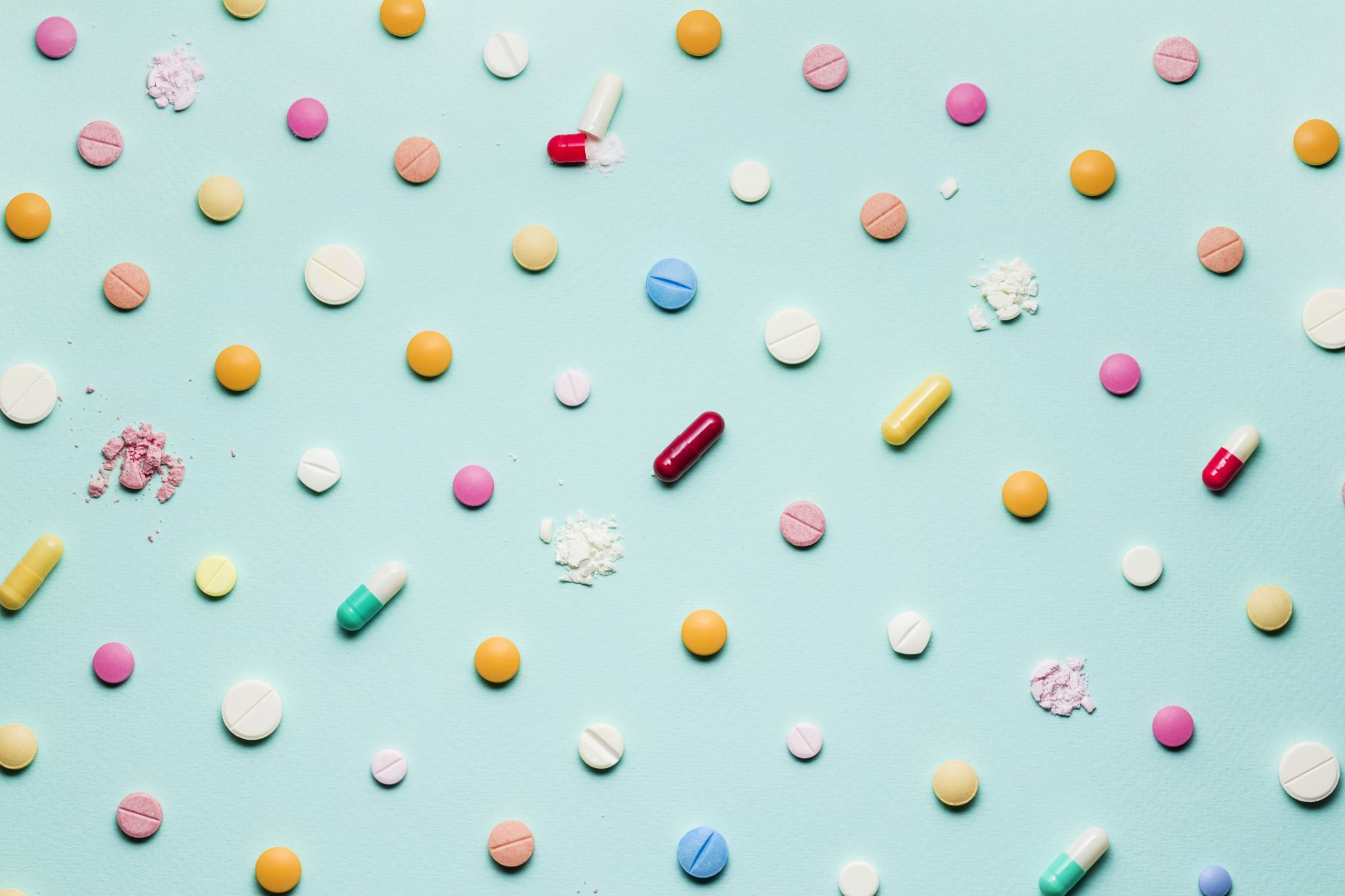 Tabletten in verschiedenen Formen abgebildet auf einem hellblauen Hintergrund. 
