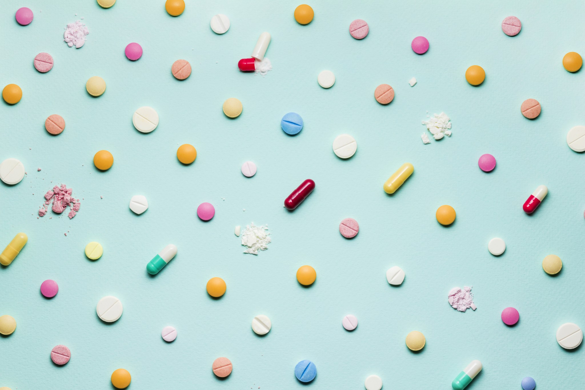 Tabletten in verschiedenen Formen abgebildet auf einem hellblauen Hintergrund.