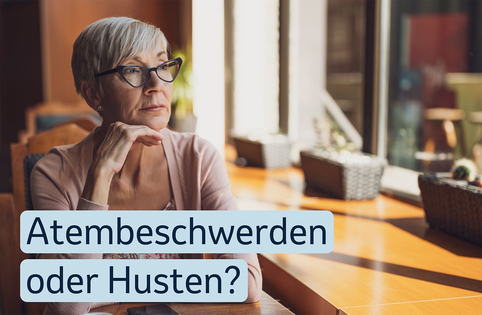Eine ältere Frau sitzt nachdenklich im Café. Auf dem Bild steht der „Atembeschwerden oder Husten?”.